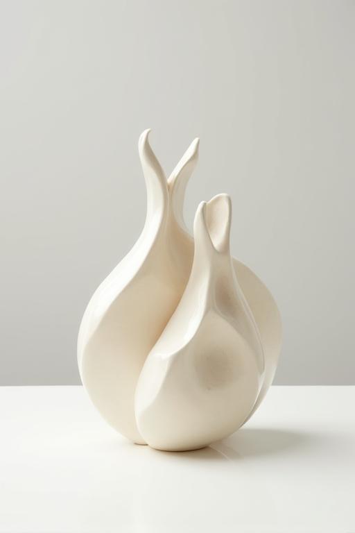 Sculpture céramique abstraite aux formes douces et organiques, de couleur crème.